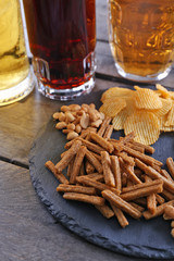 Various types of beer and snacks on wooden table