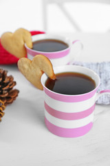 Heart shape cookie on cup of coffee on table closeup