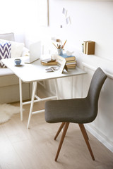 Modern interior. Comfortable workplace. Table with laptop and cup of coffee on it