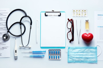 Doctor table with medicines, stethoscope and glasses, top view