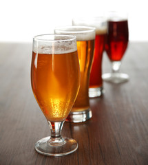 Glasses with different sorts of craft beer on wooden table
