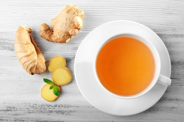 Cup of tea with ginger on a light wooden background