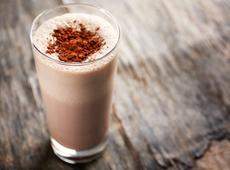 Delicious milk cocktail on rustic background, close up