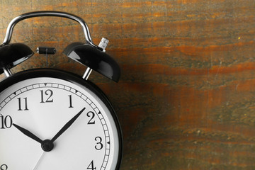 Naklejka premium Alarm clock on old wooden table.