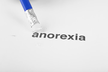 Anorexia word with pencil eraser on white paper background