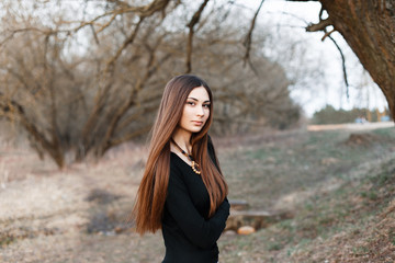Stylish girl standing near the tree in early spring.