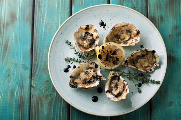 Baked oysters with sauce and cheese on a plate