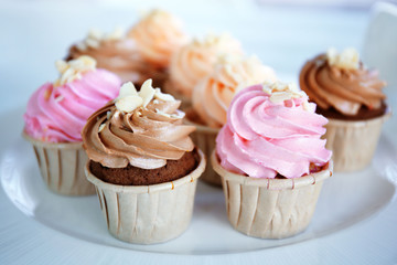 Creamy cupcakes on table closeup