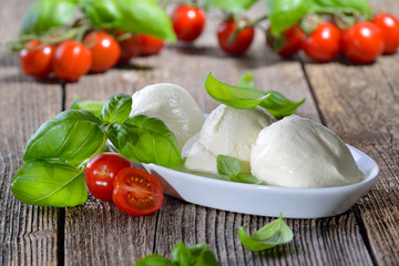 Drei Mozzarella - Kugeln in einer weissen Schale, mit Cherry-Tomaten und Basislikum, Zutaten für Caprese -  Three mozzarella cheese balls in a white bowl, garnished with cherry tomatoes and basil  © kab-vision