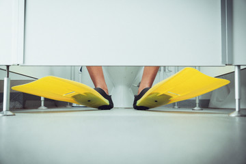 Boy wearing flippers in the toilet