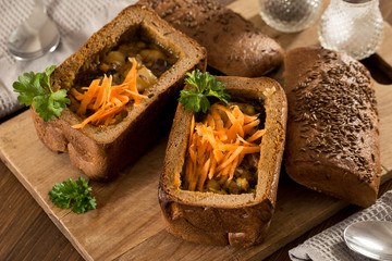 Fresh pea soup in bread bowl on a wooden desck