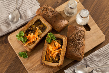 Fresh pea soup in bread bowl on a wooden desck