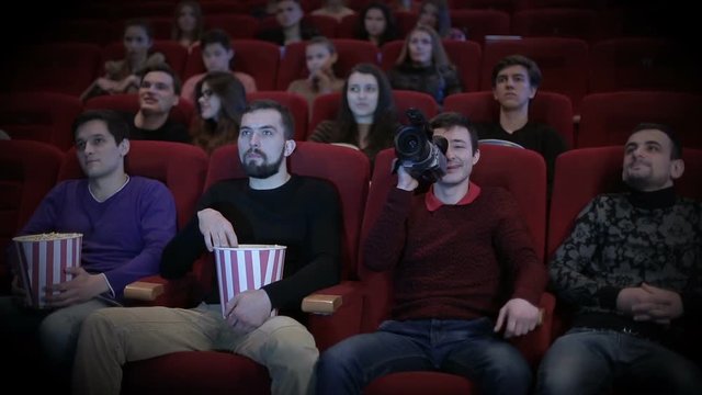 Young man pirating at the cinema
