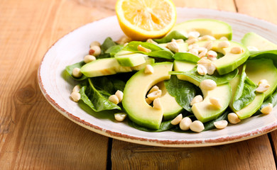 Spinach, avocado and peanuts salad on plate
