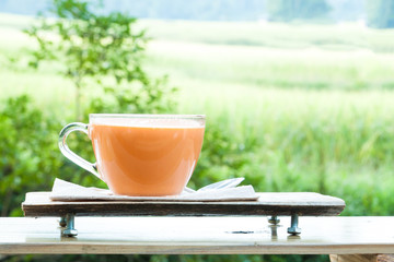 Hot milk tea on natural green background