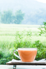 Hot milk tea on natural green background