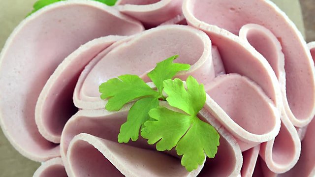 Portion of rotating sliced Mortadella as not seamless loopable 4K footage