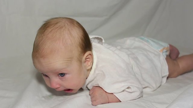 baby lies on her stomach and lifts her head