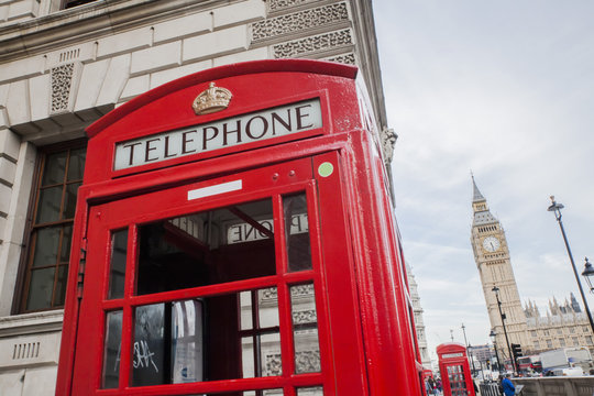 red telephone booth in London England on against big Ben