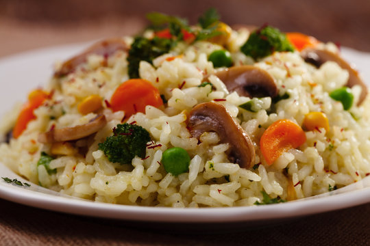 Classic Risotto with mushrooms and vegetables served on a white