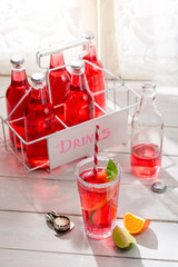 Tasty red summer drink in bottle with mint leaf