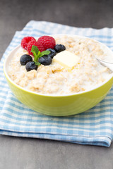 Oatmeal porridge in bowl with berries raspberries and blackberri