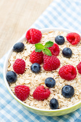 Oatmeal porridge with berries. Raspberries and blueberries.