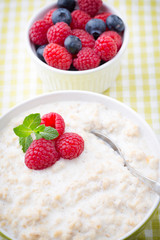 Oatmeal porridge in bowl with berries raspberries and blackberri