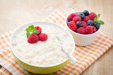 Oatmeal porridge in bowl with berries raspberries and blackberri