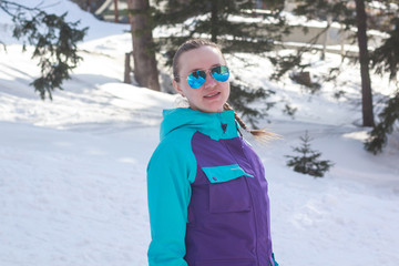 Fototapeta na wymiar young girl in sunglasses on a background of snow