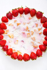 Cake with strawberries, gelly yogurt and cherries isolated on white background. Shot from above