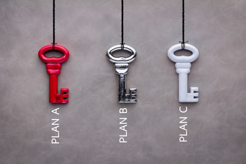 three keys red silver and white on grey background