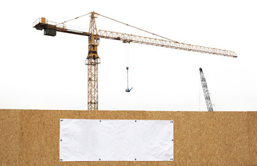 Minimalistic construction site with cranes on white background and wall with copy space banner