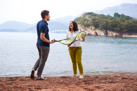Two young people playing on the seashore speedminton - badminton