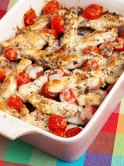 Italian chicken bake casserole with mozzarella, cherry tomatoes and oregano, vertical shot