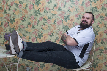 The bearded man sits at a table in an atmosphere of 