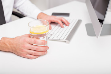 Man at the office drinking lemon water