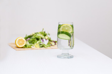 Glass glass with water and lemon slices and cucumber