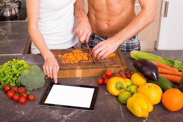 Two people using blank screen tablet in kitchen