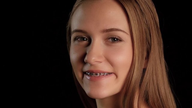 Girl with braces and blue eyes. Black