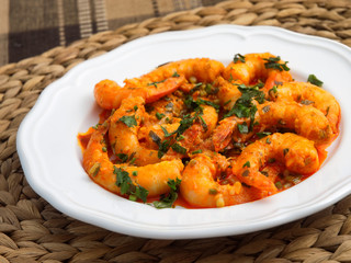 Pan fried shrimps with tomatoes, garlic and basil sauce. Horizontal shot