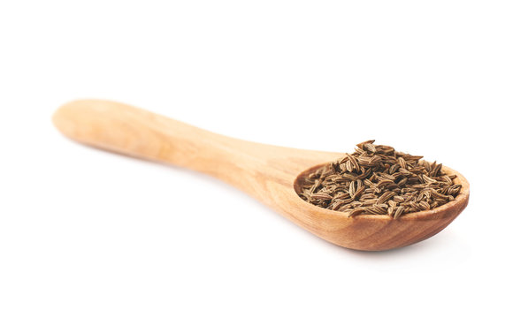 Wooden spoon full of cumin seeds