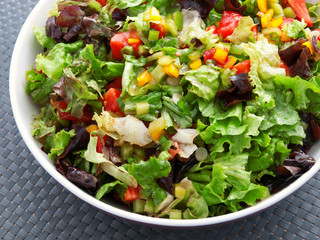 Green salad with tomatoes and peppers. Vertical shot, high angle view