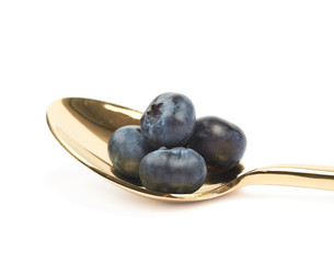 Golden spoon full of bilberries