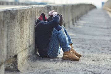 young homeless boy sleeping on the bridge