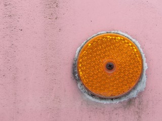 Rundes Katzenauge in Orange als Reflektor auf alter verwaschene Fassade in Rosa und Pink im Stadtteil Olderdissen in Bielefeld am Hermannsweg im Teutoburger Wald in Ostwestfalen-Lippe