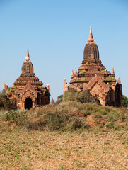 Two ancient pagodas in Bagan, Myanmar, blue sky in background.Vertical shot