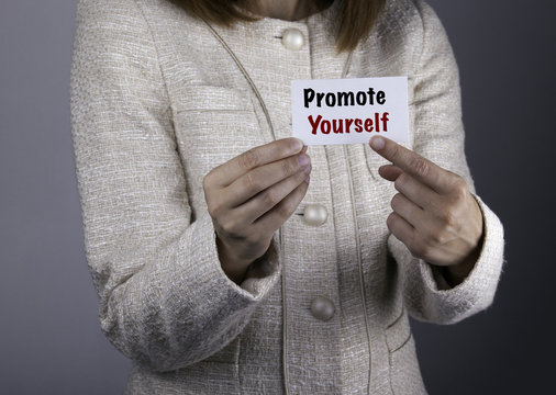 Promote yourself. Businesswoman holding a card with a message te
