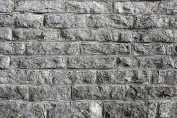Серый гранит. Текстура стены из серого рваного камня с выпуклым швом.