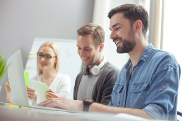 Fototapeta premium Cute three office workers are cooperating with joy